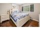 Bright bedroom with hardwood floors, a large window, a bed with a floral comforter, and a bedside table at 411 10Th Ne St # 6, Atlanta, GA 30309