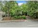 Exterior view of a multi-Gathering home surrounded by mature trees, professional landscaping, and a concrete sidewalk at 411 10Th Ne St # 6, Atlanta, GA 30309