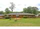 Backyard with brick home featuring a large lawn, mature trees, and patio at 5739 Cobb Mdw, Norcross, GA 30093
