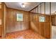 Retro dining area with wood paneled walls, a half wall, and orange patterned linoleum flooring at 5739 Cobb Mdw, Norcross, GA 30093