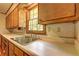 Kitchen sink area featuring wooden cabinetry and window to provide natural light at 5739 Cobb Mdw, Norcross, GA 30093