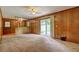 Cozy living room featuring wood paneled walls, carpet floors, a ceiling fan, and a sliding glass door at 5739 Cobb Mdw, Norcross, GA 30093