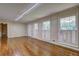 Spacious living room with hardwood floors, white trim, and ample natural light from three large windows at 5739 Cobb Mdw, Norcross, GA 30093