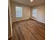 Inviting bedroom showcasing gleaming hardwood floors and two windows for natural light at 602 Birch River Ln, Lawrenceville, GA 30043