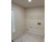 Clean laundry room featuring a white wire shelf, tile flooring, and window at 602 Birch River Ln, Lawrenceville, GA 30043