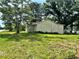 Exterior shot of a modest home surrounded by mature trees and an expansive grassy lawn at 1891 Bennett Rd, Grayson, GA 30017