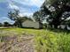 Rear view of a modest home with a plain, windowless exterior and overgrown surroundings, showcasing its compact structure at 1891 Bennett Rd, Grayson, GA 30017