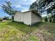 A side view of a small house with a plain exterior and overgrown surroundings, emphasizing its modest size and features at 1891 Bennett Rd, Grayson, GA 30017