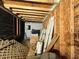View of an unfinished room showing a wood beam ceiling, plywood walls, stacked doors and stored items at 1891 Bennett Rd, Grayson, GA 30017