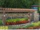 Stone community entrance sign with wood pergola and colorful flowerbeds beneath, offering a welcoming view at 450 Hunt Creek Dr, Acworth, GA 30101