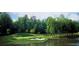 Scenic golf course with a pond, sand trap, and lush green landscaping at 450 Hunt Creek Dr, Acworth, GA 30101