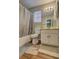 Bathroom featuring a shower-tub combination, white vanity, and wood-look flooring at 5026 Brittany Dr, Stone Mountain, GA 30083