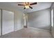Spacious bedroom featuring neutral walls, ceiling fan, carpet flooring and large closet at 5026 Brittany Dr, Stone Mountain, GA 30083