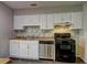Bright kitchen features white cabinets, mosaic backsplash, and stainless steel appliances at 5026 Brittany Dr, Stone Mountain, GA 30083
