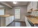 Bright kitchen showcasing white cabinets, updated countertops and backsplash, and window views at 5026 Brittany Dr, Stone Mountain, GA 30083