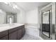 Modern bathroom featuring double sinks, bathtub, glass-door shower, and gray vanity at 57 Forsyth Nw St # 16G, Atlanta, GA 30303