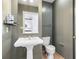 Neutral toned powder room features a pedestal sink, toilet and wall mirror at 57 Forsyth Nw St # 16G, Atlanta, GA 30303