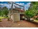 View of the backyard showing a deck and patio area with landscaping, trees, and ample green space at 1248 Rockview Ct, Loganville, GA 30052