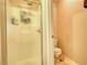 Bathroom features a shower with glass doors, toilet, and cream-colored walls at 1248 Rockview Ct, Loganville, GA 30052
