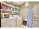 Well-equipped laundry area with appliances, storage shelves, and a convenient ironing board at 1248 Rockview Ct, Loganville, GA 30052