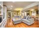 Cozy living room featuring a large sectional sofa, hardwood floors, and connecting to a dining area at 1248 Rockview Ct, Loganville, GA 30052