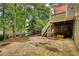 Spacious outdoor patio area with stairs leading to a raised deck surrounded by mature trees at 1248 Rockview Ct, Loganville, GA 30052