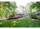 Expansive backyard with a covered deck, well-maintained lawn, and mature trees at 2639 Hummingbird Nw Dr, Duluth, GA 30096