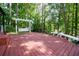Large outdoor wooden deck with a swing, bench seating and picturesque wooded views at 2639 Hummingbird Nw Dr, Duluth, GA 30096