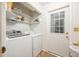 Functional laundry room with a washer, dryer, shelving for storage, and access to the exterior at 2639 Hummingbird Nw Dr, Duluth, GA 30096