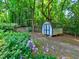 Backyard with a storage shed surrounded by greenery and flowers at 4512 Woodlawn Lake Dr, Marietta, GA 30068