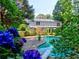 Lush backyard featuring a sparkling pool, mature trees, and vibrant landscaping, creating a serene outdoor oasis at 4512 Woodlawn Lake Dr, Marietta, GA 30068