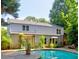 Back of house overlooking a swimming pool and landscaped backyard surrounded by trees at 4512 Woodlawn Lake Dr, Marietta, GA 30068