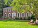 Charming brick two-story home with a well-manicured lawn and beautiful landscaping at 4512 Woodlawn Lake Dr, Marietta, GA 30068