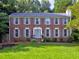 Traditional brick home with a well-maintained lawn, symmetrical design, and inviting curb appeal at 4512 Woodlawn Lake Dr, Marietta, GA 30068
