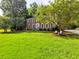 Spacious brick home with a green lawn, mature trees, and classic architectural details at 4512 Woodlawn Lake Dr, Marietta, GA 30068