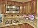 Close-up of kitchen with granite countertops, gas cooktop, and stainless steel microwave at 4512 Woodlawn Lake Dr, Marietta, GA 30068