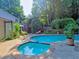 Backyard pool with a jacuzzi and stone surround next to mature landscaping at 4512 Woodlawn Lake Dr, Marietta, GA 30068
