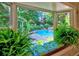 Picturesque view of the backyard pool surrounded by lush greenery, as seen from a window seat at 4512 Woodlawn Lake Dr, Marietta, GA 30068