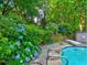 Inviting pool area with lush hydrangeas, clear blue water, and well-maintained landscaping at 4512 Woodlawn Lake Dr, Marietta, GA 30068