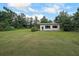 A well-manicured backyard with a detached building surrounded by lush trees at 6880 Mark Turner Rd, Lithia Springs, GA 30122