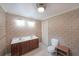 Bathroom features double sink vanity with cherry wood cabinets, wallpaper and toilet in an enclosed area at 6880 Mark Turner Rd, Lithia Springs, GA 30122