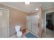 Bathroom featuring toilet, shower, and wallpaper, creating a functional and serene space at 6880 Mark Turner Rd, Lithia Springs, GA 30122