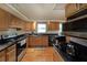Well-equipped kitchen featuring sleek black countertops, efficient appliances, and classic wood cabinets at 6880 Mark Turner Rd, Lithia Springs, GA 30122
