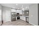 A kitchen featuring stainless steel appliances, white cabinetry, and unique hanging lights at 2793 Keystone Ave, Lithonia, GA 30058