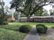A well maintained front yard with mature trees and bushes leading to a red brick apartment building at 425 Lindbergh Ne Dr # A2, Atlanta, GA 30305