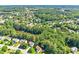 Picturesque aerial view of a neighborhood nestled among mature trees and a pond at 7505 Brookwood Way, Cumming, GA 30041