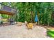 A cozy backyard setup with Adirondack chairs around a fire pit, with a deck above at 7505 Brookwood Way, Cumming, GA 30041