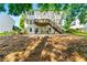 Large backyard featuring a wooden staircase leading to a deck, a grill, and a gravel area with seating at 7505 Brookwood Way, Cumming, GA 30041