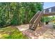 Backyard featuring a wooden staircase leading to a deck, a grill, and a gravel area with seating at 7505 Brookwood Way, Cumming, GA 30041