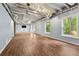 Spacious basement with light blue walls, wood-look flooring, exposed ceiling, and natural light from large windows at 7505 Brookwood Way, Cumming, GA 30041